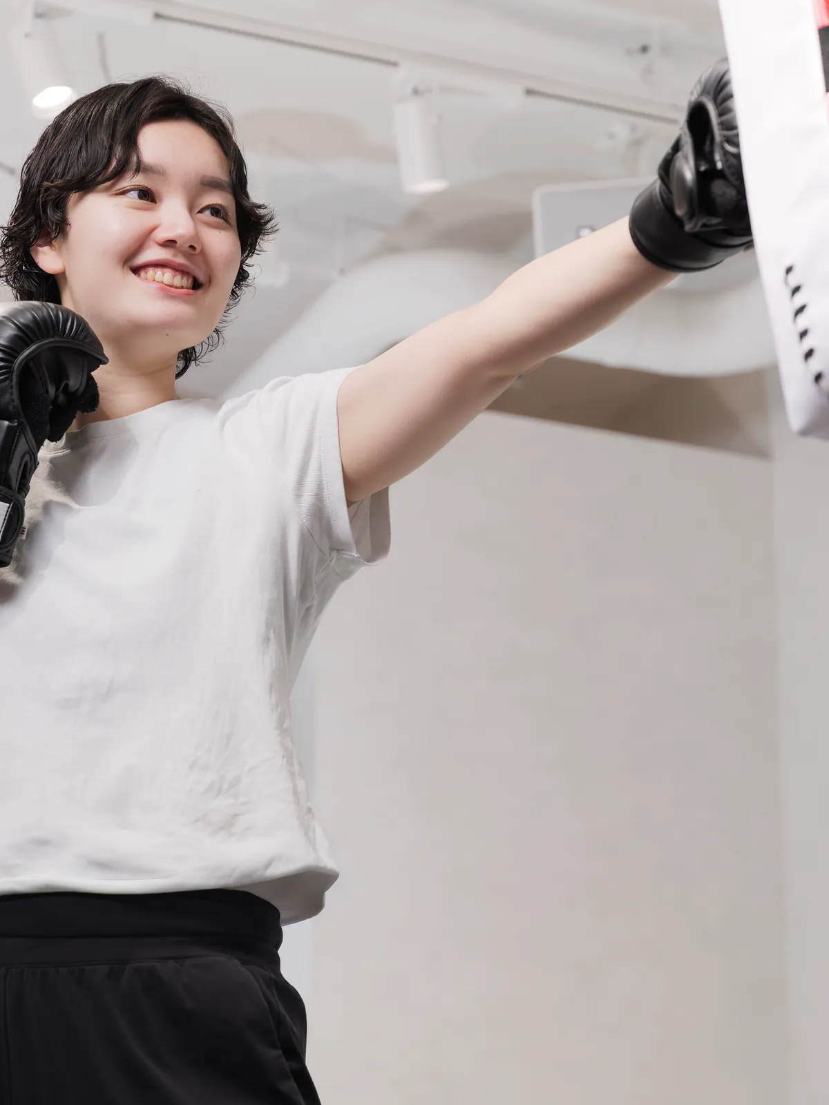 インストラクターの構えるミットにパンチを放つ会員